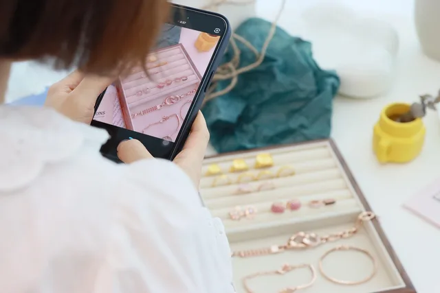 filming, cell phone, prop, jewelry, ring, necklace, studio, model, woman, craft, social media. Does a Belfast UGC contract trade into the EU under the Windsor Framework?