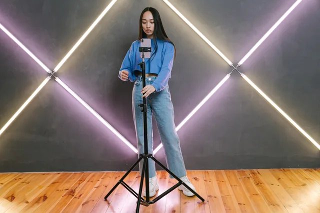 Asian woman preparing for a livestream with smart phone on tripod indoors. UGC marketplaces business models: a comparison framework