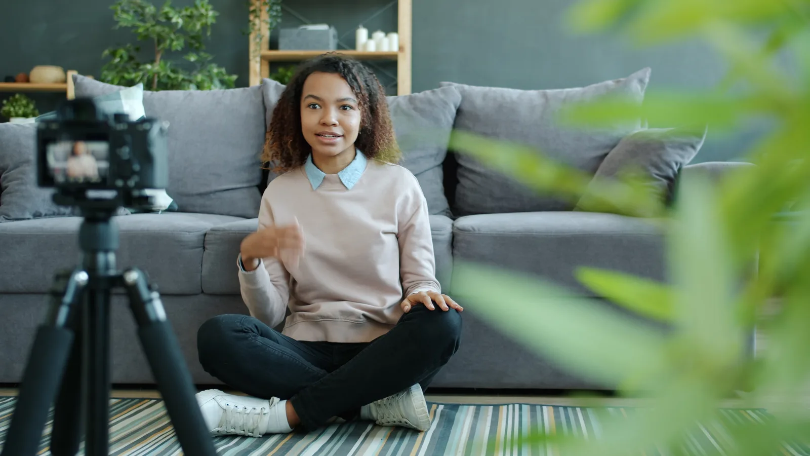 A young woman creates content for her vlog at home, sitting in front of a camera.