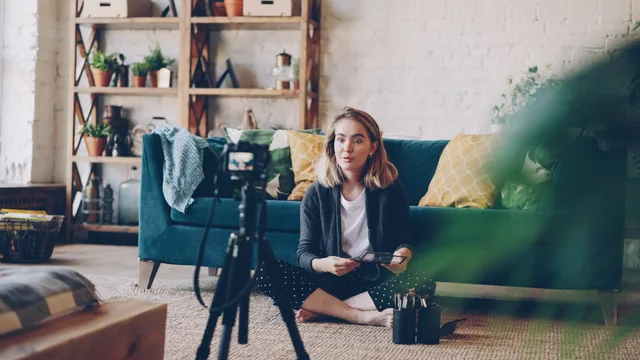 Woman filming vlog at home with camera setup, surrounded by plants and cozy decor. Five UGC risk scenarios, from expired rights to a supplier losing publishing access