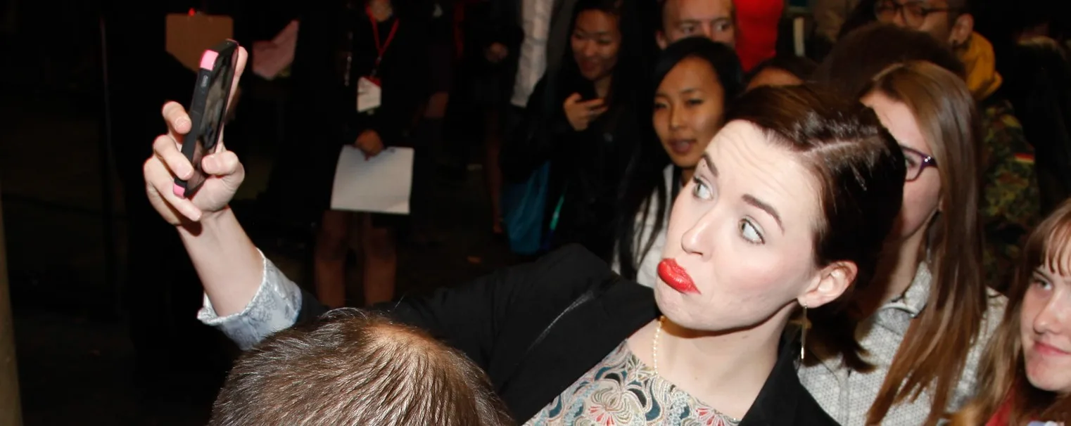 Attendee at the 2013 Buffer Festival Gala mugs for a selfie.